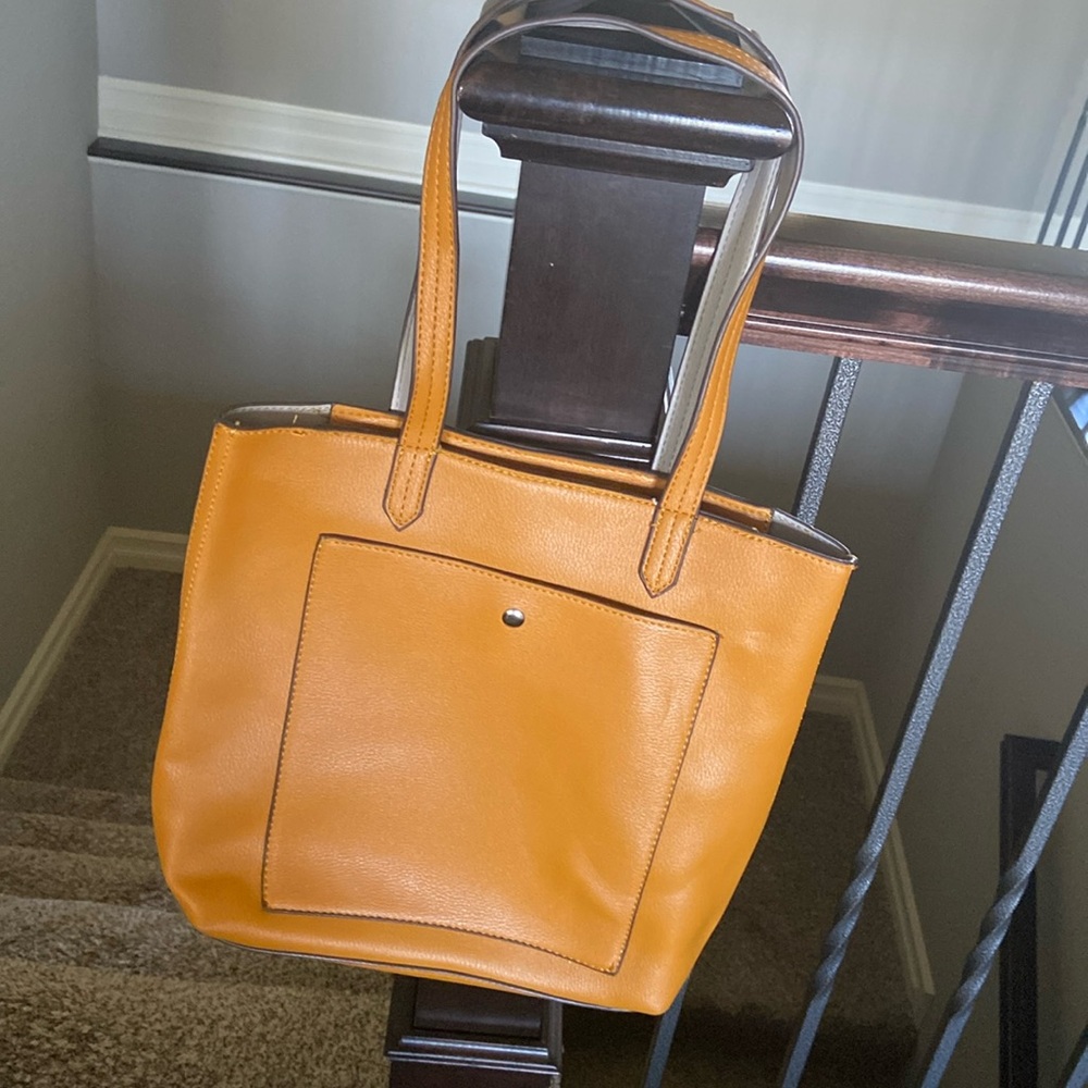 Dark mustard handbag has multiple pockets and shoulder strap. Collection XIIX